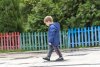 122311135-yound-boy-walking-around-in-a-park-with-his-head-down-with-a-colorful-fence-in-the-b...jpg