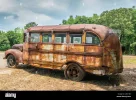 old-rusty-abandoned-school-bus-from-the-1940s-parked-in-a-field-with-a-flat-tire-and-broken-w...webp