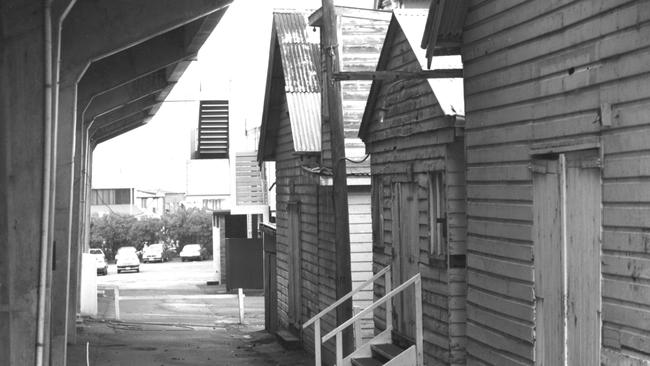 Old timber pavilions at Brookvale Oval dwarfed by the new concrete grandstand just before they were demolished